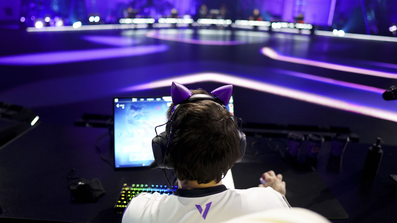 Version1 VALORANT player wearing cat ears on stage at a Riot Games LAN event.