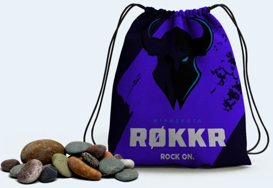 A purple drawstring bag with a Minnesota Røkkr logo on it and a small pile of rocks next to it.